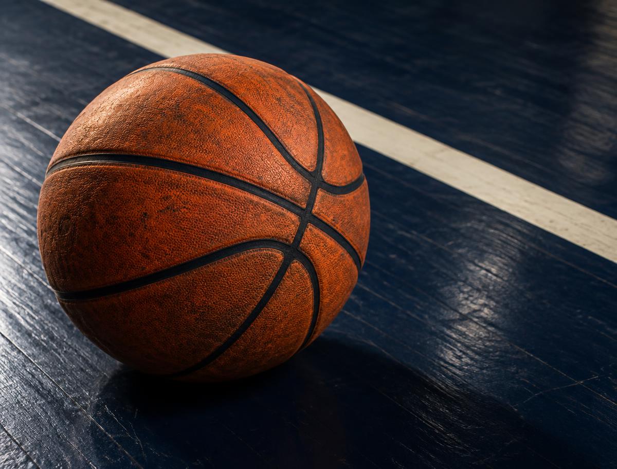 An orange basketball resting on a navy court floor beside a painted line